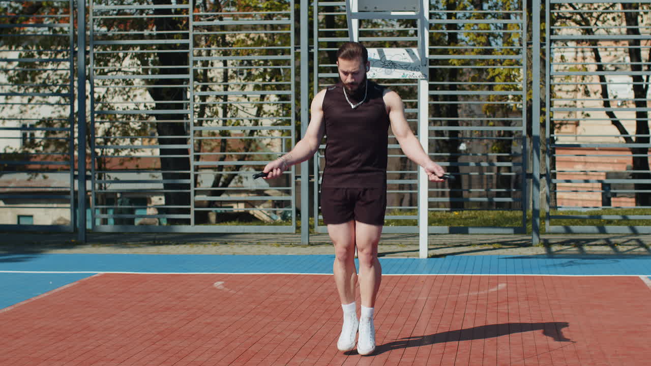 hombre atlético libanés en ropa deportiva saltando la cuerda haciendo ejercicios de salto en la cancha de baloncesto