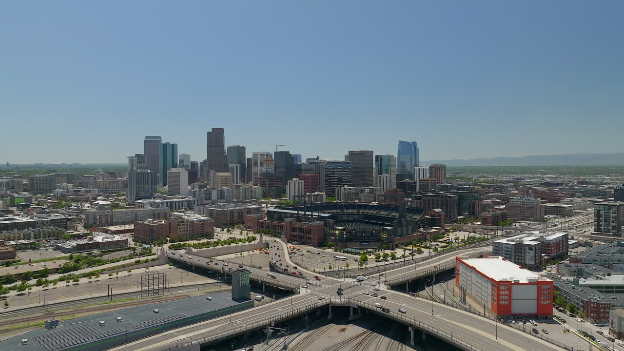 Centro di Denver, Coors Field, stadio di baseball dei Colorado Rockies, paesaggio delle Montagne Rocciose, Monte Evans, riprese aeree cinematografiche da drone, pedemontana, traffico di auto del Colorado, treni Amtrak, primavera, estate, movimento in avanti.