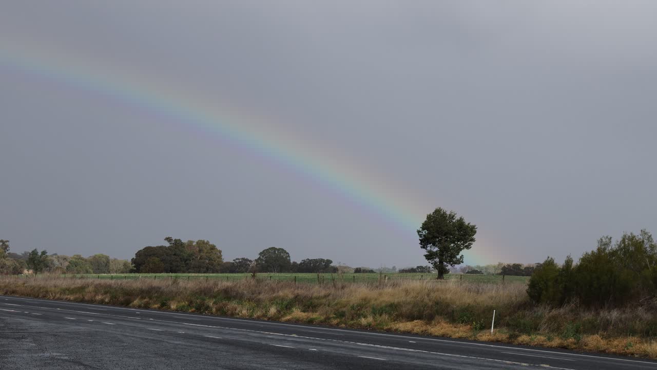 el arco iris se desvanece gradualmente en un entorno rural nublado