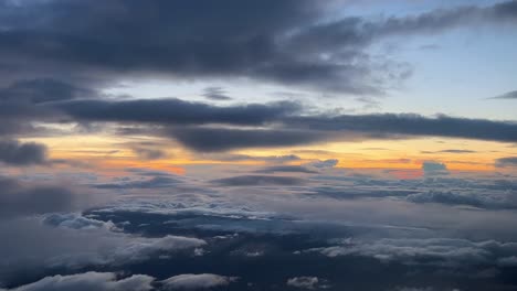 la perspectiva de un piloto de una hermosa puesta de sol mientras vuela a través de algunas nubes a 12000 m de altura hacia el oeste