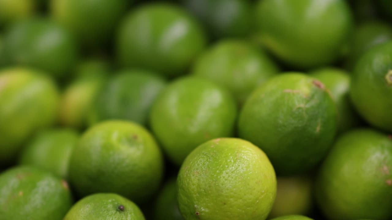 A detailed close-up of fresh, green limes showcasing their vibrant color and texture.