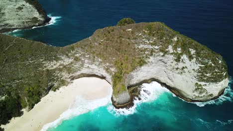 toma de drones de olas rompiendo en la playa de kelingking en la isla de nusa penida, indonesia
