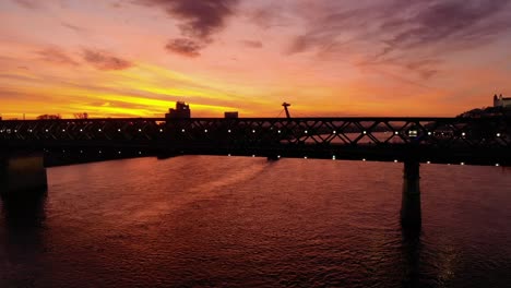 Soaring-drone-shot-of-the-Old-Bridge-above-the-Donau-during-twilight-in-Bratislava,-Slovakia