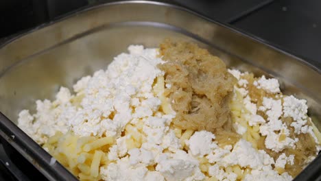 the chef seasons the filling for dumplings made of cheese and potatoes