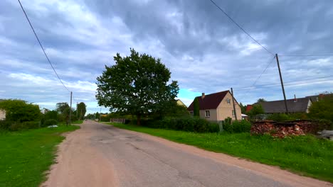 latvian rural village road with house and tree and electric cable latgale