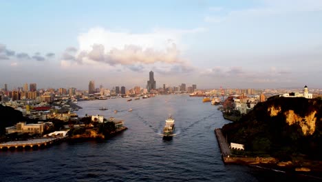 Golden-hour-over-bustling-harbor-with-city-skyline,-boats-in-motion,-ocean-view,-aerial-shot