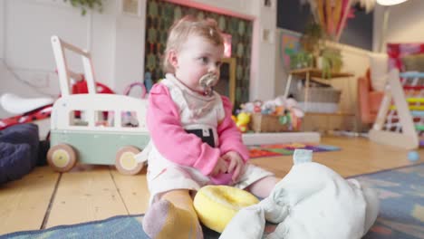 infant gently rocking backwards and forwards on the family home floor