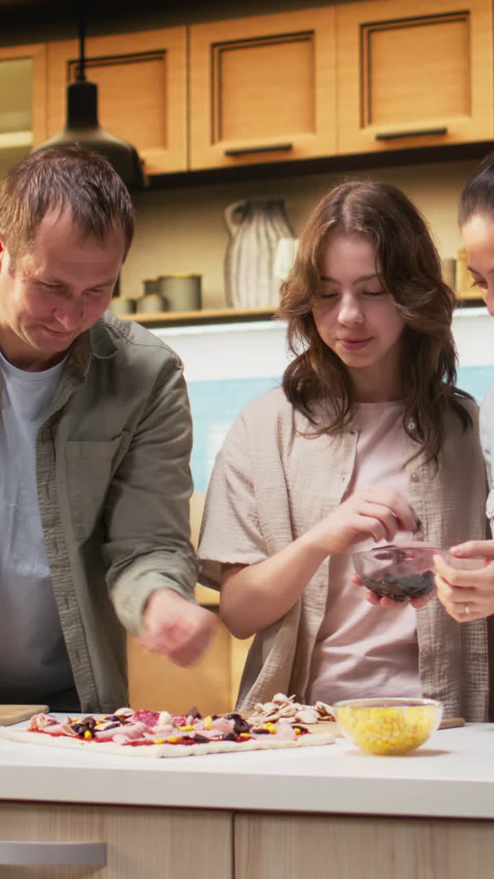 Vertical Video Joyful family making homemade pizza together and sharing laughter