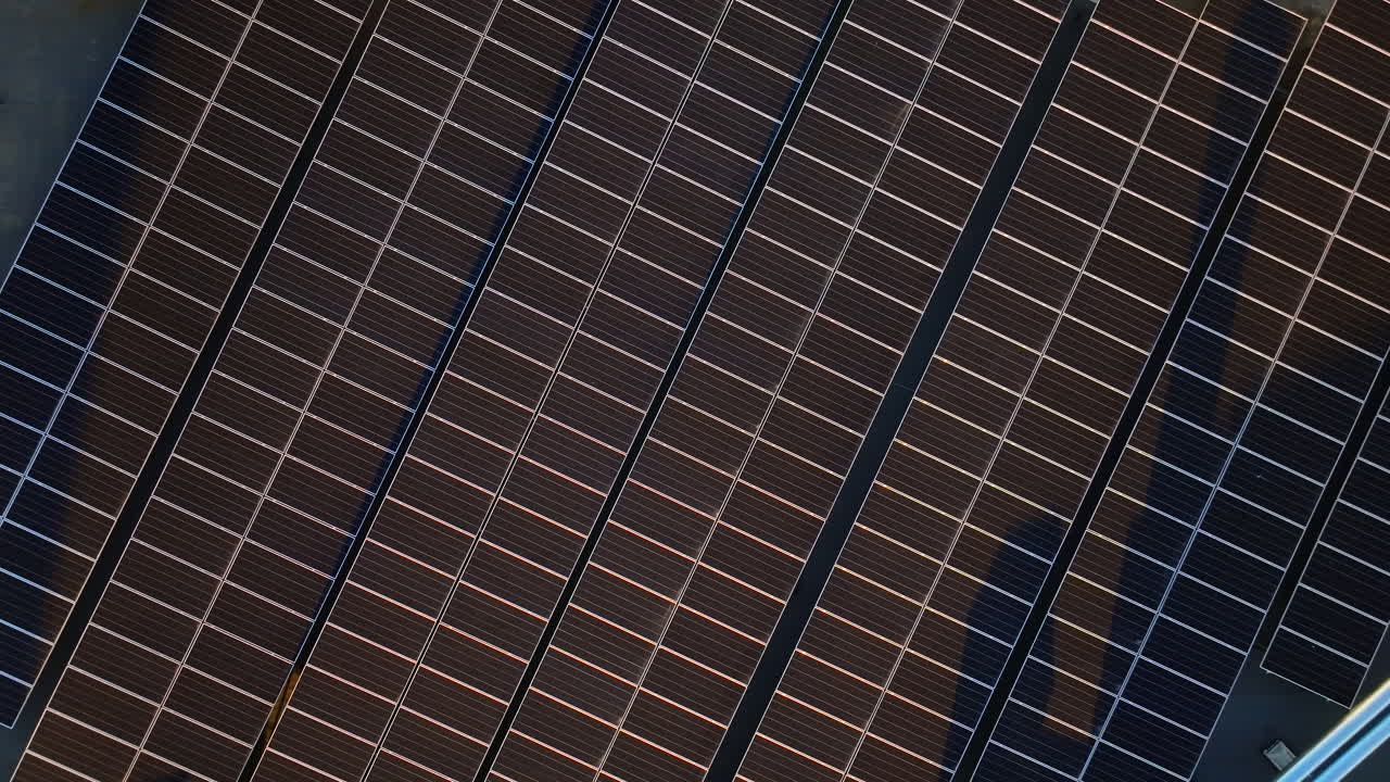 Vista aerea di pannelli solari al tramonto ripresa da un drone. Pannelli fotovoltaici sul tetto dell'edificio. Fonte di energia alternativa. Concetto di risorse sostenibili