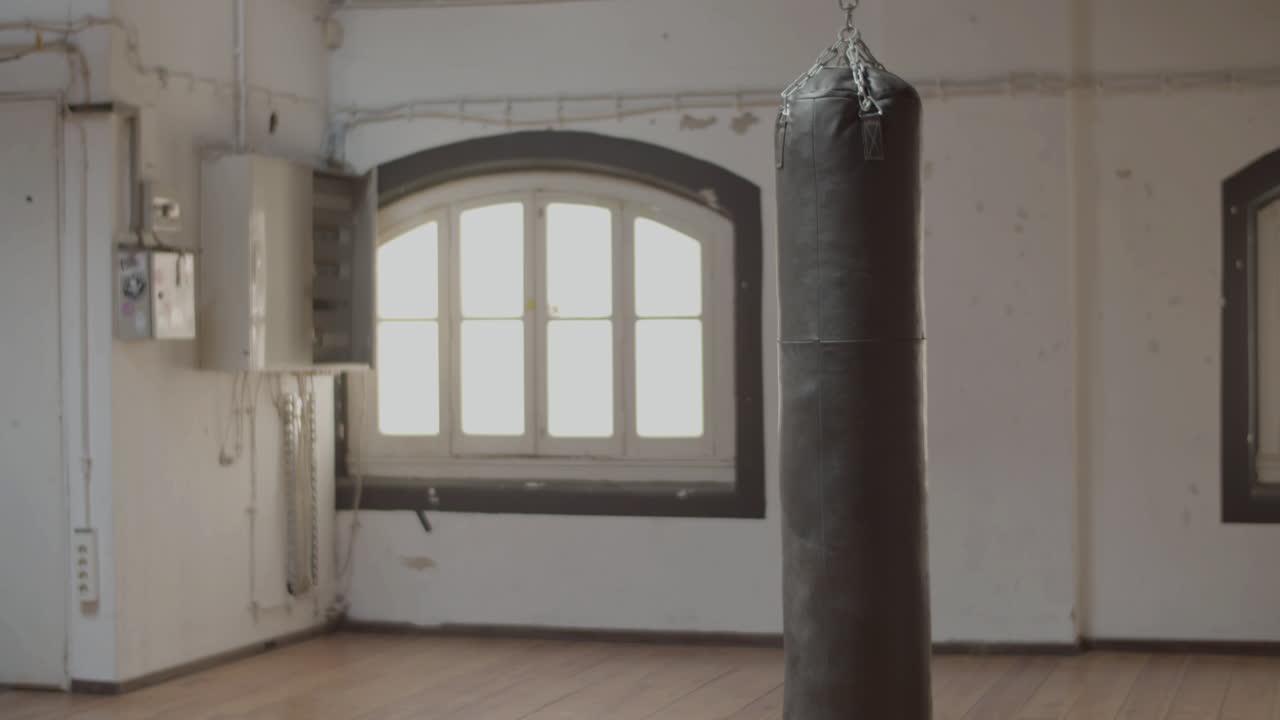 체육관 에서 높은 무 ⁇  을 가지고 달리는 여자 권투 선수 의 측면 전망