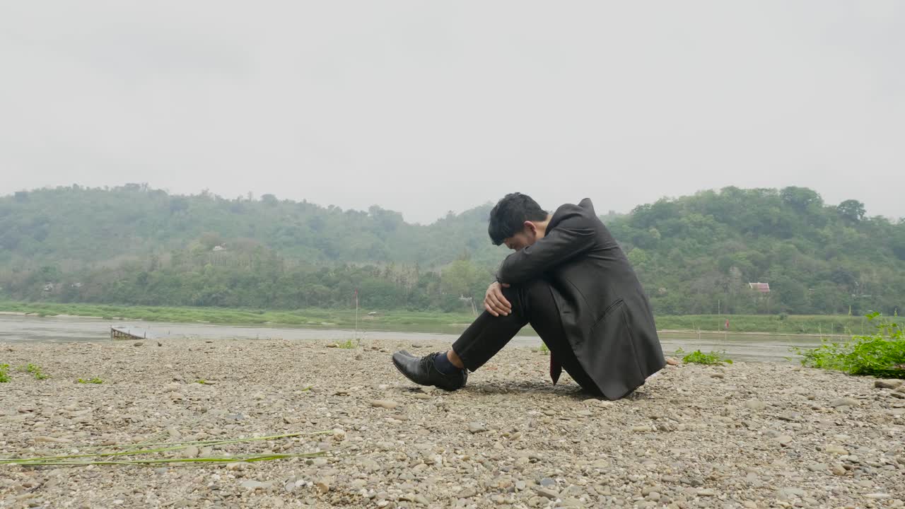 A Sad Businessman by the River