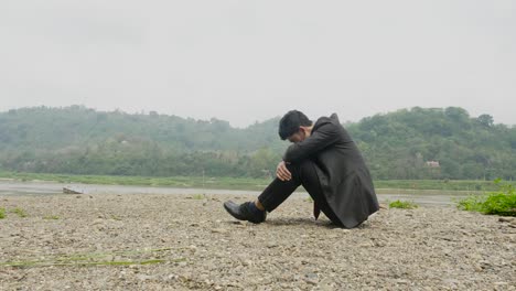 a sad businessman by the river