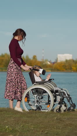 girl with disability plays with virtual reality glasses. preschooler looks at hands and picks up objects in digital game. mother and daughter rest together