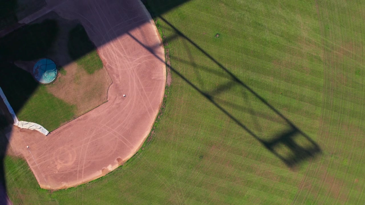 Campo da baseball nell'America rurale, ripresa aerea fluida del campo esterno e del diamante, 4K