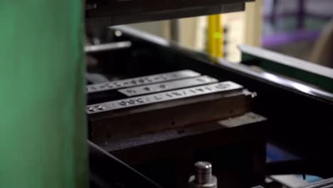 a metal stamping machine presses identification numbers into the drum lids