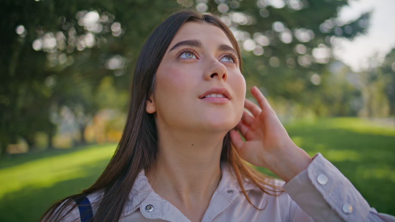 content mujer disfrutando del jardín verde soleado retrato. primer plano chica serena en el parque