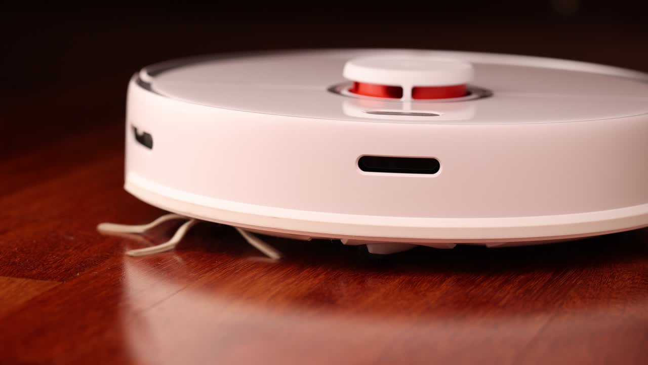 나무 바닥에 리더를 가진 스마트 로 진공청소기 로 진소기는 아파트의 자동 청소를 수행합니다. 느린 동작 100fps.