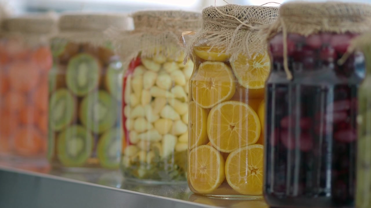 Fileira de Potes de Vidro Cheios de Frutas e Legumes em Conserva