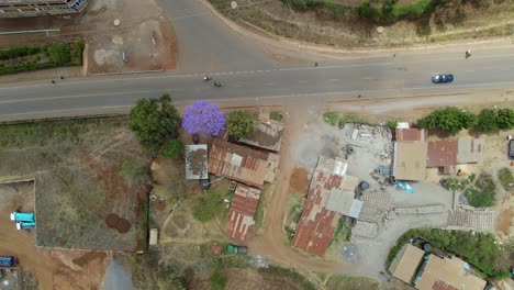 Aerial-view-of-a-town-and-sunlit-fields,-golden-hour-in-rural-Africa---tracking,-drone-shot