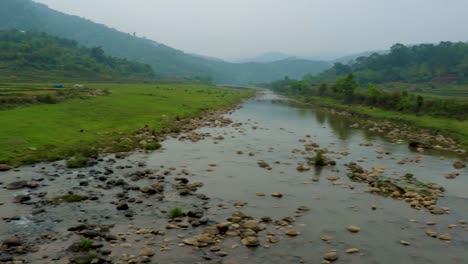 river leading to the misty mountain with cloudy sky at morning from flat angle