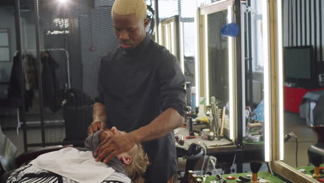 barber putting towel on face of client