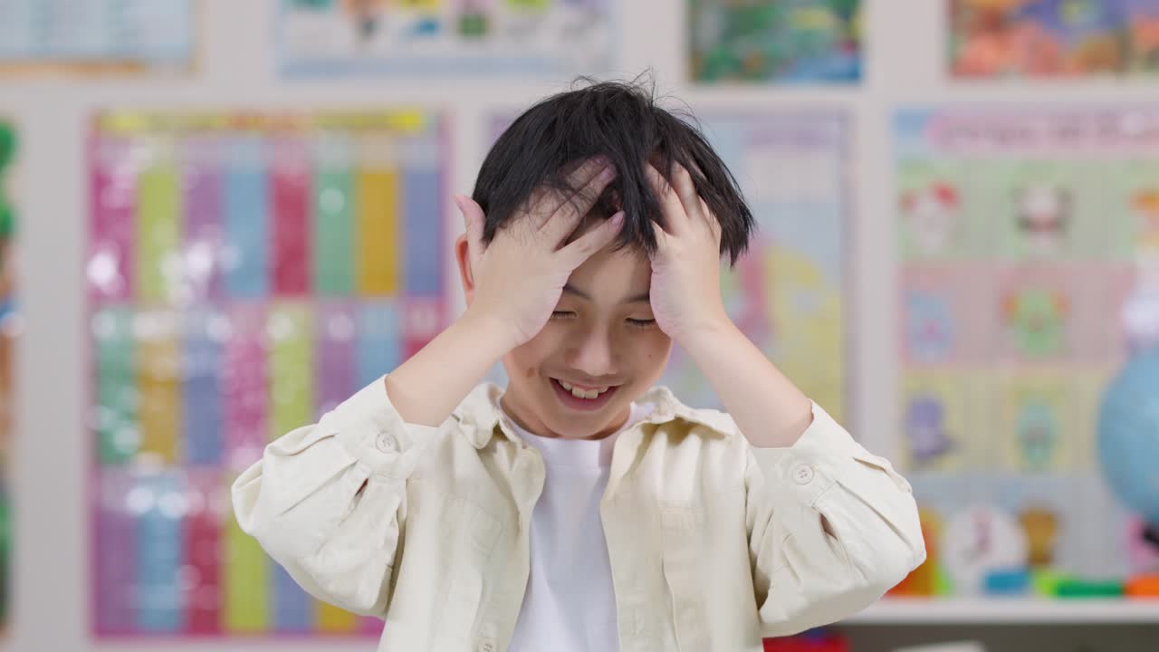 Ragazzino si tocca la testa in classe, mostrando stress o mal di testa sotto una luce intensa e uniforme