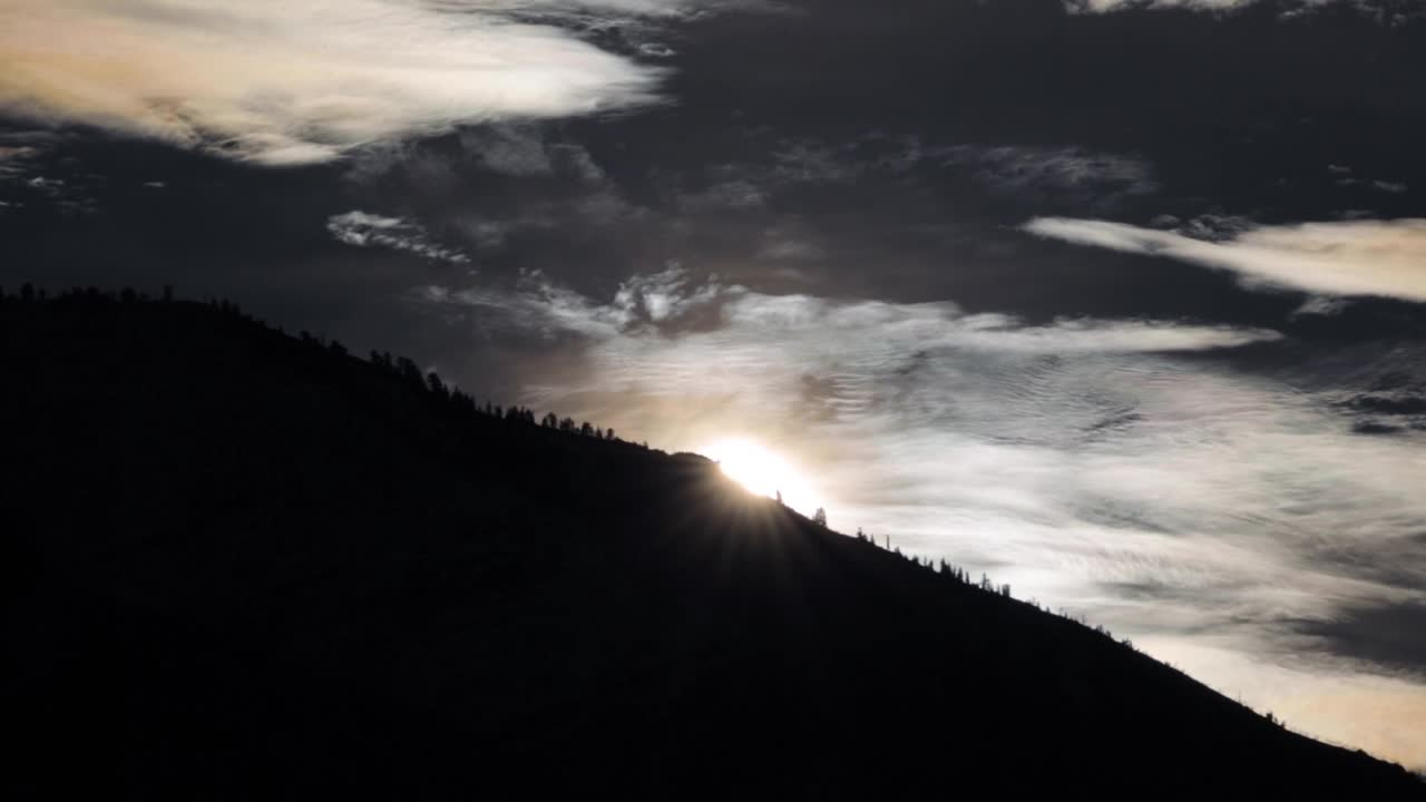 Majestic sunrise over an ominous silhouetted mountain