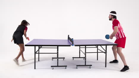 playing table tennis, man and woman competing in studio match