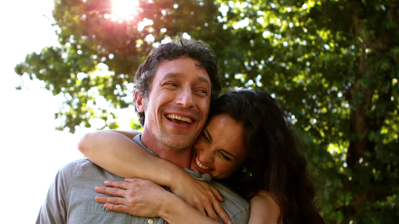 una pareja sonriente abrazándose