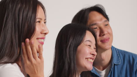 색 스튜디오 배경 앞의 젊은 친구 그룹의 측면 뷰 사진 부스 스타일 초상화 1