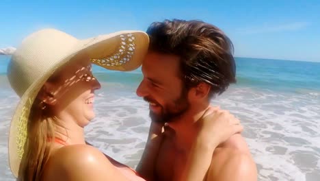 una joven pareja abrazándose en la playa
