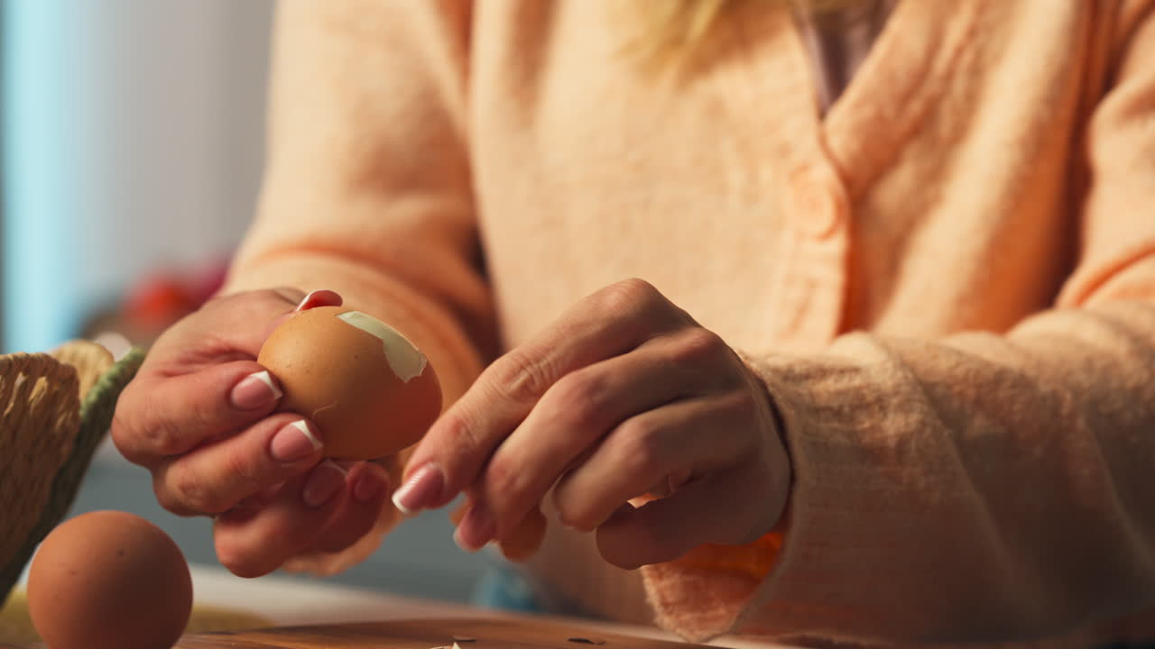 Hands Cracking Hard-boiled Egg On Surface And Peeling It. close-up shot