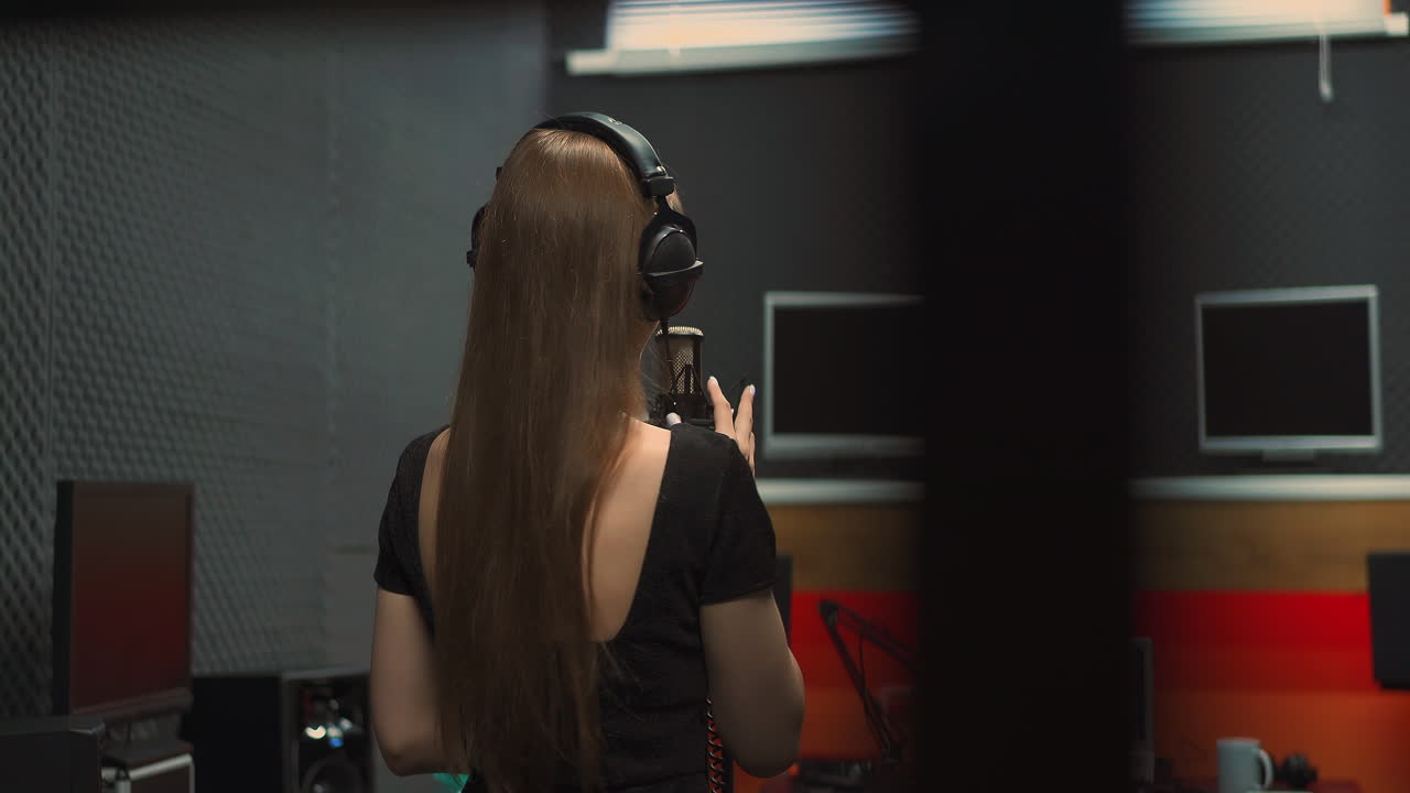 드레스를 입은 우아한 여성 가수가 노래를 연주합니다.