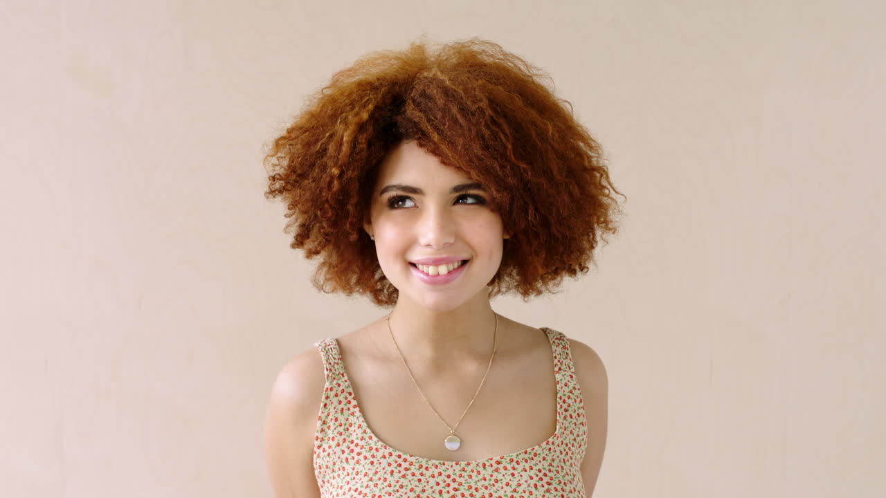 retrato de una mujer nerviosa con un afro rojo