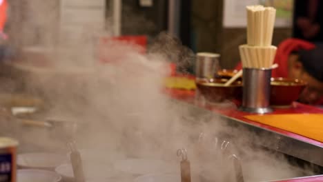 puestos de comida humeantes con cocineros y clientes ocupados