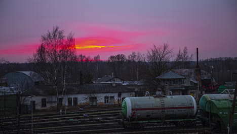 Blutroter-Sonnenuntergangshimmel-über-Altem-Industriebahnhof,-Fusionszeitraffer