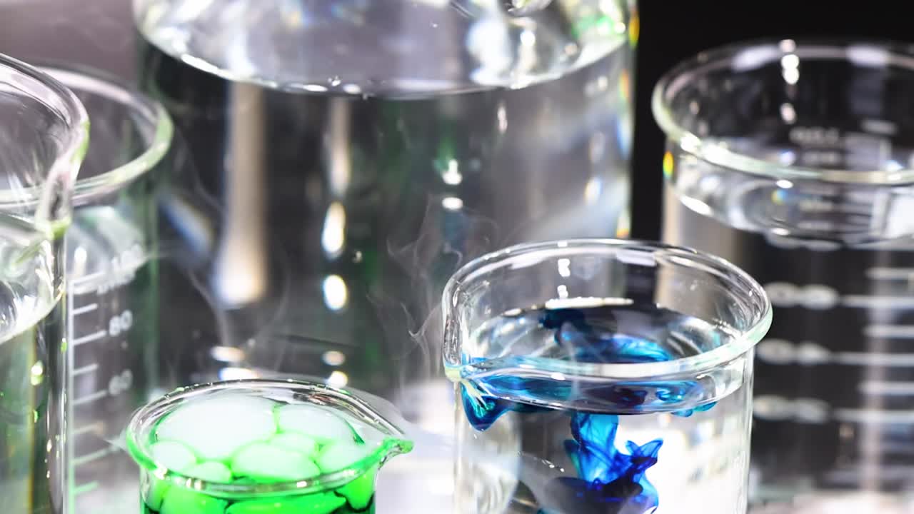 A vivid chemical reaction with blue and green liquids creating smoke in laboratory beakers.