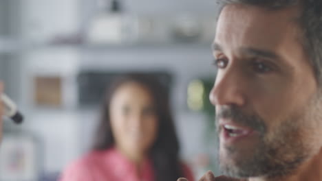 hombre de negocios en la oficina creativa escribiendo ideas en una pantalla transparente hablando con una colega