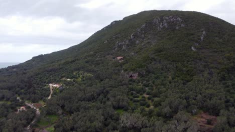 Perfect-aerial-view-flight-long-fly-forwards-drone-footage-to-a-big-cave-in-a-mountain-in-the-wild-nature-Corfu-wait-for-explorer-in-Greece