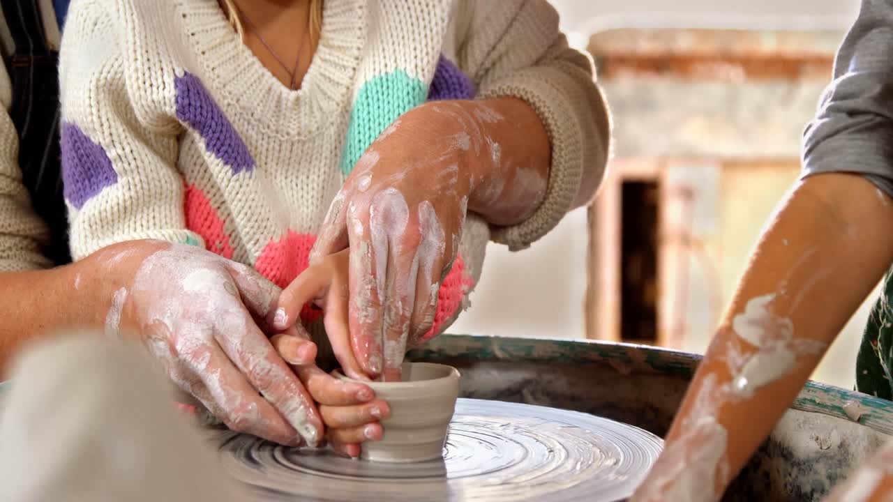 una alfarera ayudando a una niña