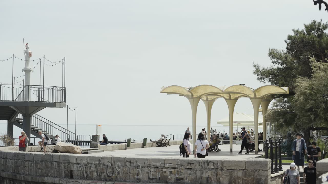 paseo marítimo costero con personas y características arquitectónicas