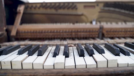 dolly pan of old broken, warped family piano