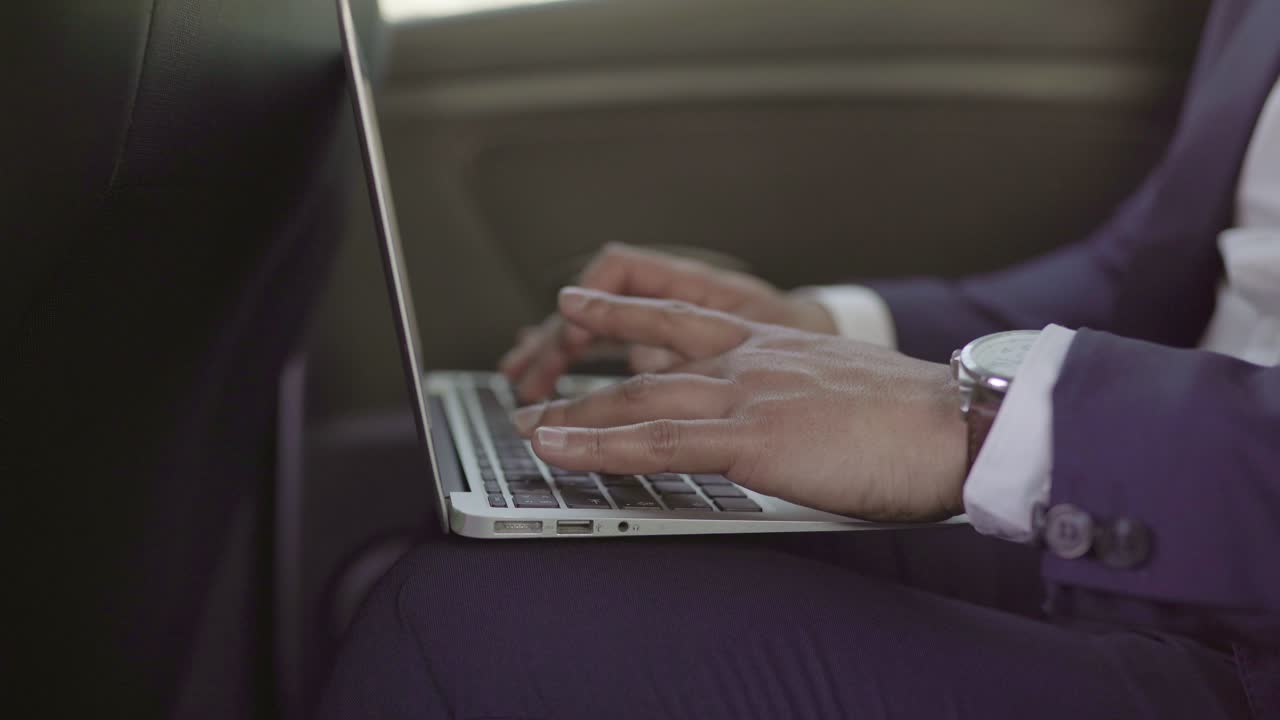 Partial view of businessman using laptop in car