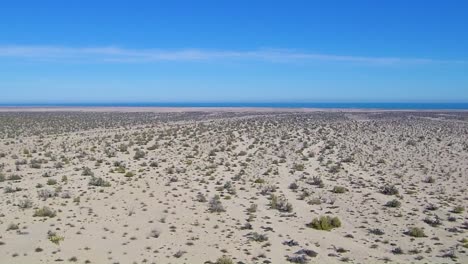 view of a drone flying around land near the ocean