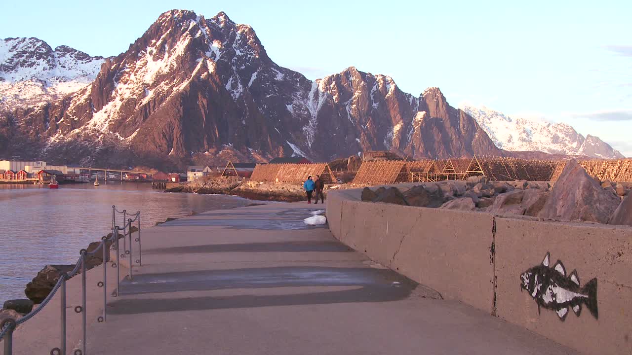 노르웨이 로포텐 섬의 북극권 북쪽 부두를 따라 걷는 사람들