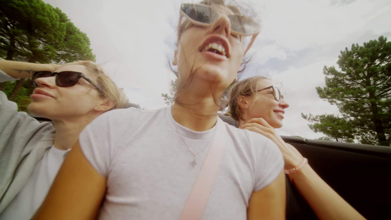 Three friends on a road trip in a convertible