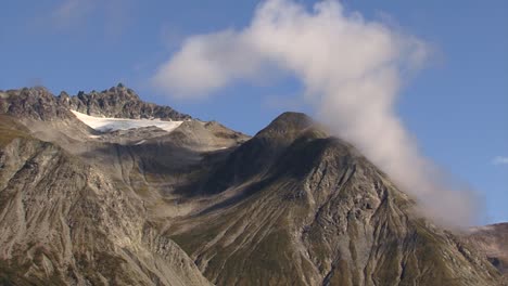 fluffy white clouds on top of the mountains