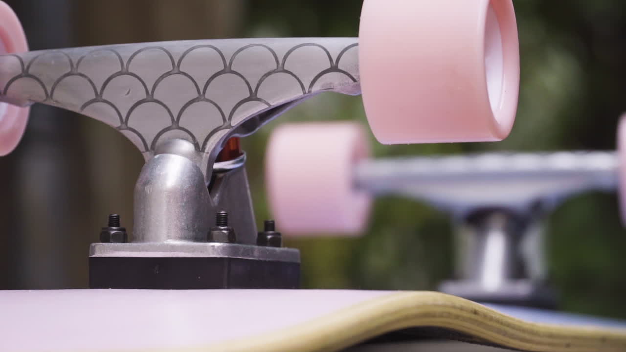 거꾸로 된 스케이트보드에 장착된 분홍색 스케이트보드 바퀴의 수평 팬으로 닫습니다.