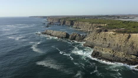 beautiful seaside cliffs and crashing waves during midday in portugal