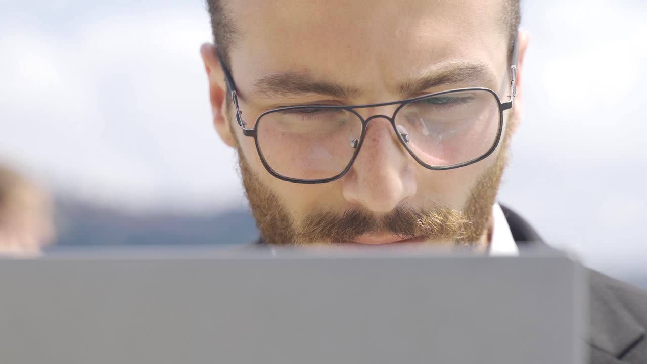 hombre de negocios trabajando en una computadora portátil junto al mar.